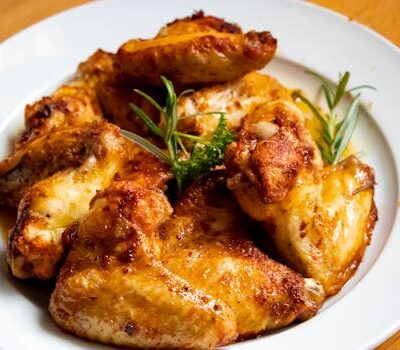 Golden-brown chicken wings garnished with fresh herbs, perfect for a tasty meal.