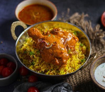 Delicious Indian chicken biryani served with accompanying curry and yogurt raita, capturing the essence of traditional cuisine.